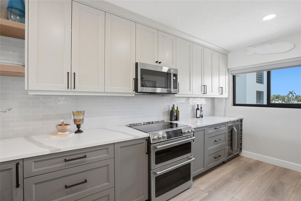 363 Pinellas Bayway South, Unit 29 Tierra Verde, FL 33715 - Photo 17 of 59 a kitchen with granite countertop white cabinets and stainless steel appliances