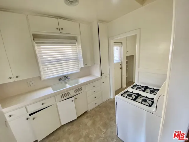 a kitchen with white cabinets and appliances