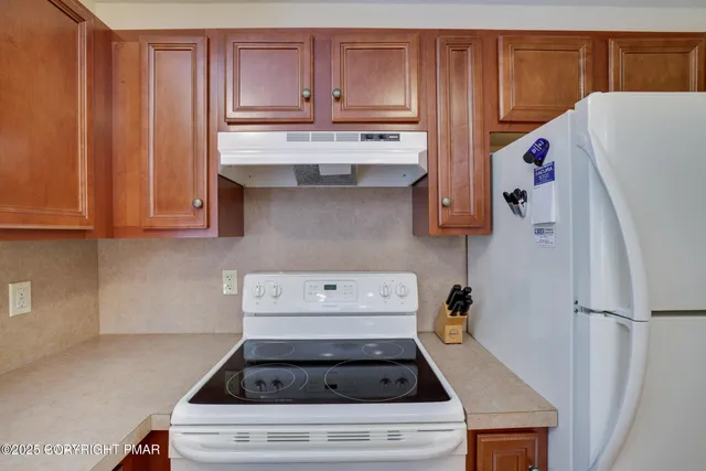 a kitchen with stainless steel appliances wooden cabinets a sink and a window