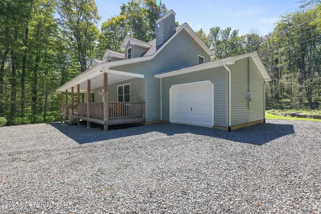 a view of a house with a yard and large tree