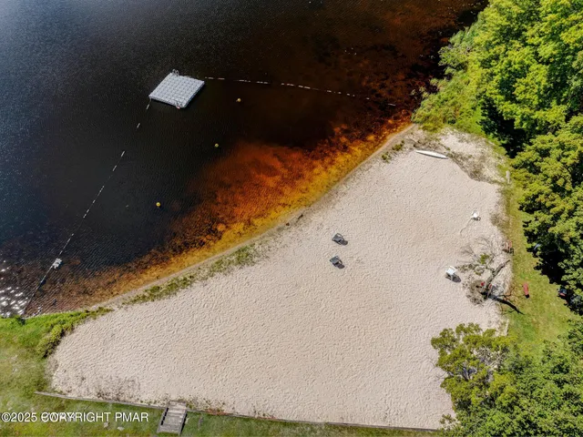an aerial view of a house with a yard and a lake view