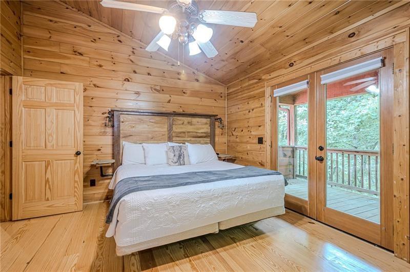 213 Moonshine Hollow Blue Ridge, GA 30513 - Photo 17 of 41 a bedroom with a bed and a chandelier