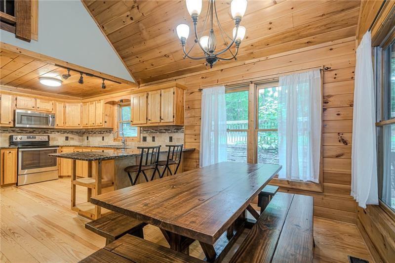 213 Moonshine Hollow Blue Ridge, GA 30513 - Photo 7 of 41 a dining room with wooden floor a table and chairs