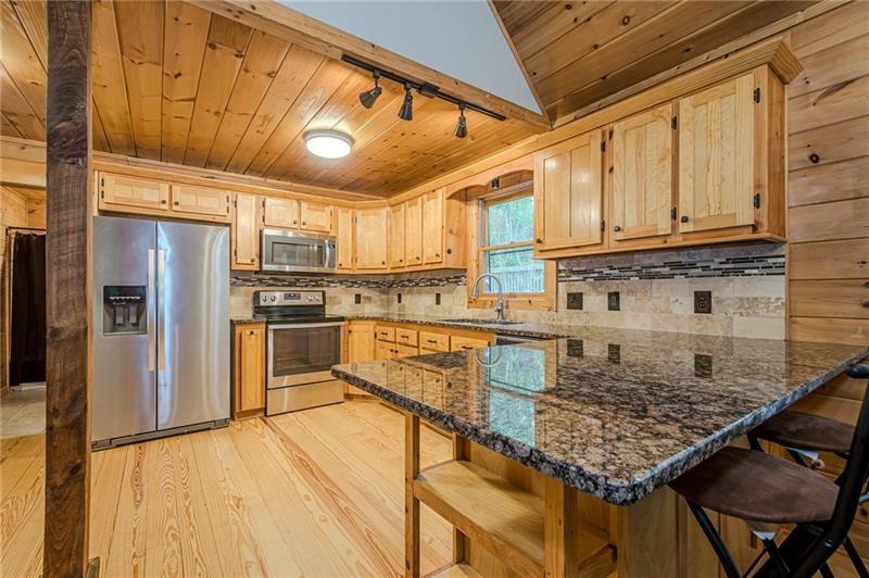 213 Moonshine Hollow Blue Ridge, GA 30513 - Photo 8 of 41 a kitchen with stainless steel appliances granite countertop a sink refrigerator and cabinets