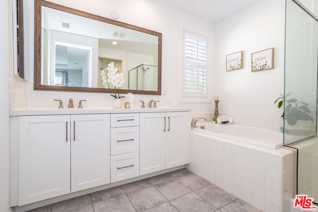 20621 West Chestnut Circle Porter Ranch, CA 91326 - Photo 11 of 30 a bathroom with a double vanity sink a mirror a bathtub and