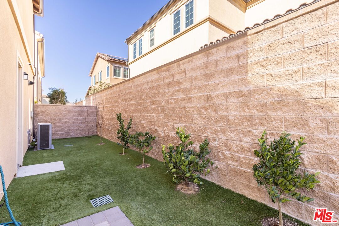 20621 West Chestnut Circle Porter Ranch, CA 91326 - Photo 25 of 30 a backyard with plants and brick wall