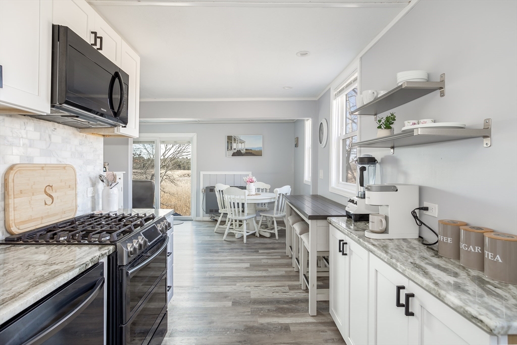 1 Ladd Avenue Wareham, MA 02571 - Photo 6 of 26 a kitchen with stainless steel appliances granite countertop a stove oven a sink dishwasher and cabinets with wooden floor