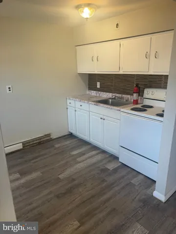 a kitchen with stainless steel appliances white cabinets and wooden floor