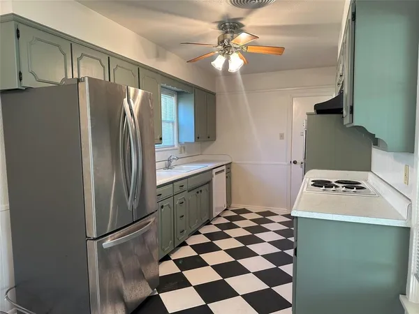 a kitchen with stainless steel appliances granite countertop a refrigerator a stove and a sink