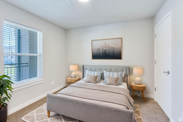 572 South 100 West, Unit E210 Springville, UT 84663 - Photo 18 of 35 Carpeted bedroom featuring a large window with blinds, a solid white door, and neutral wall tones