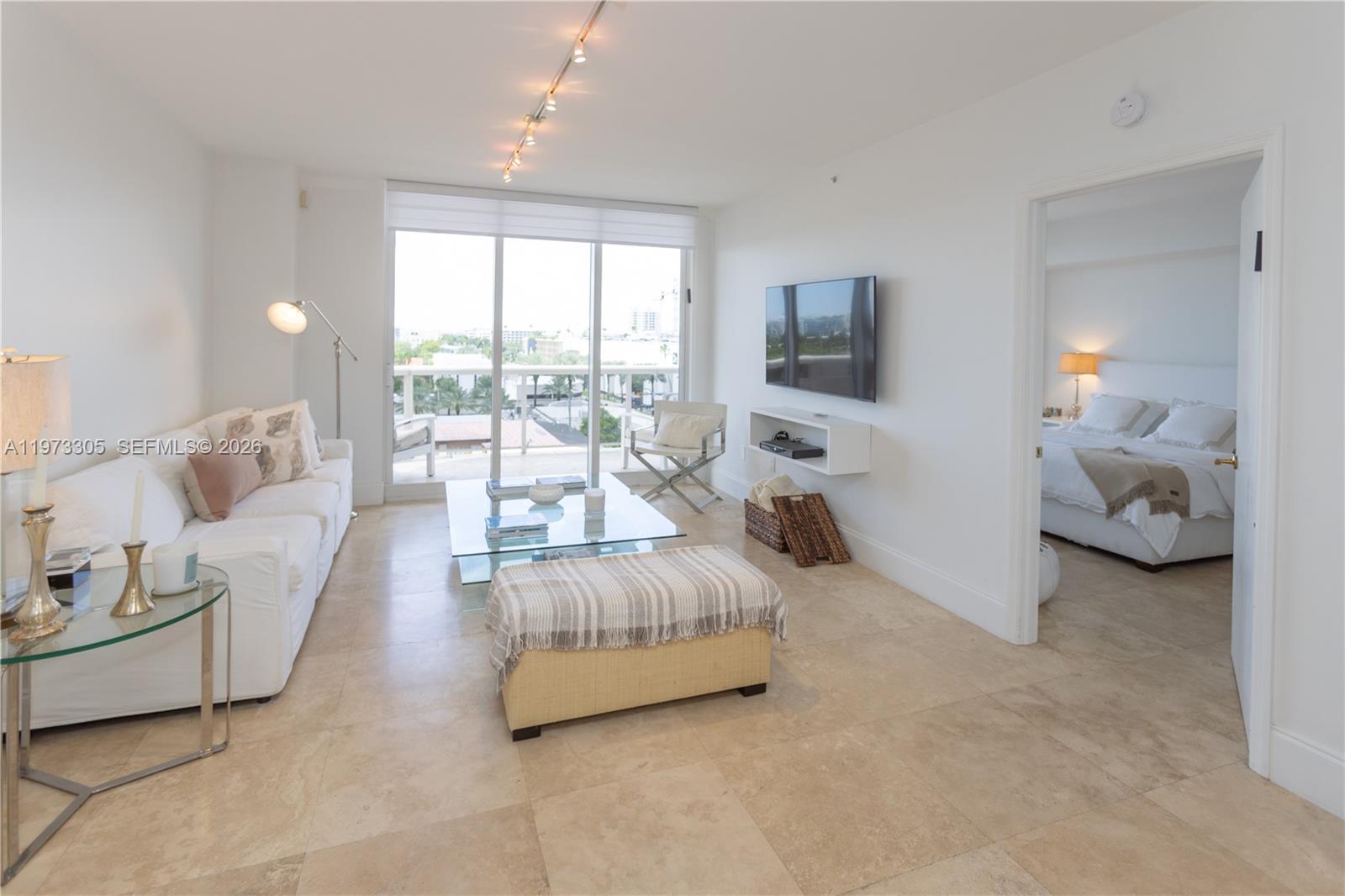 9595 Collins Avenue, Unit N6F Surfside, FL 33154 - Photo 17 of 26 a living room with furniture and a flat screen tv