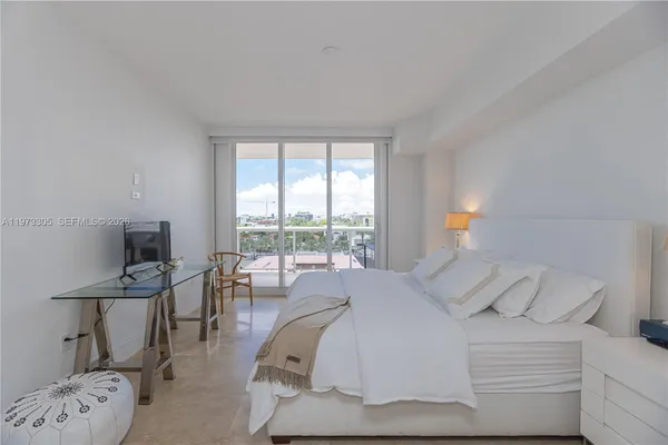 a bedroom with a bed a large window and a couch