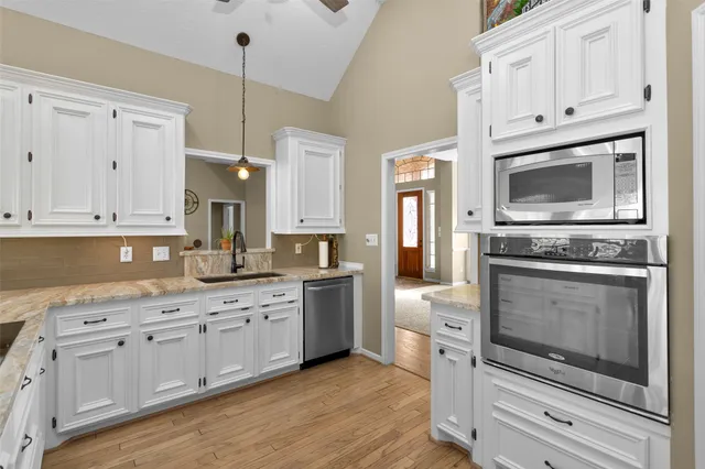 a kitchen with white cabinets stainless steel appliances and sink