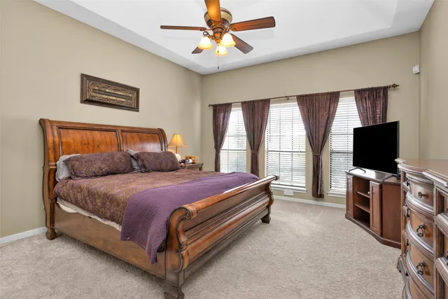 a spacious bedroom with a bed and a flat screen tv