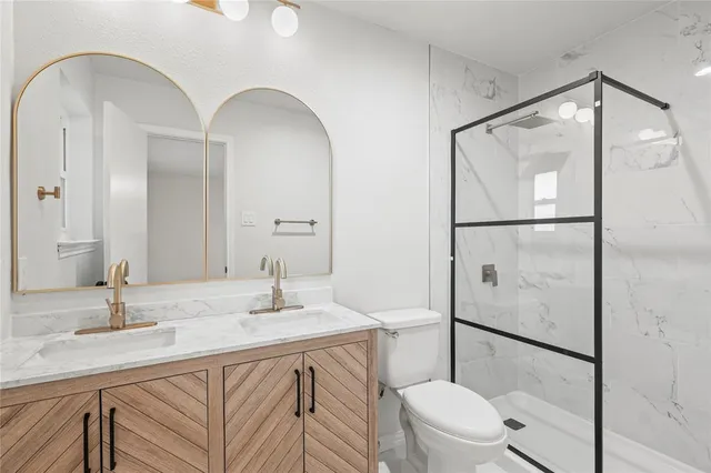 a bathroom with a sink a toilet and a large mirror