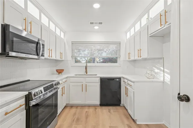 a kitchen with stainless steel appliances granite countertop a sink stove and microwave