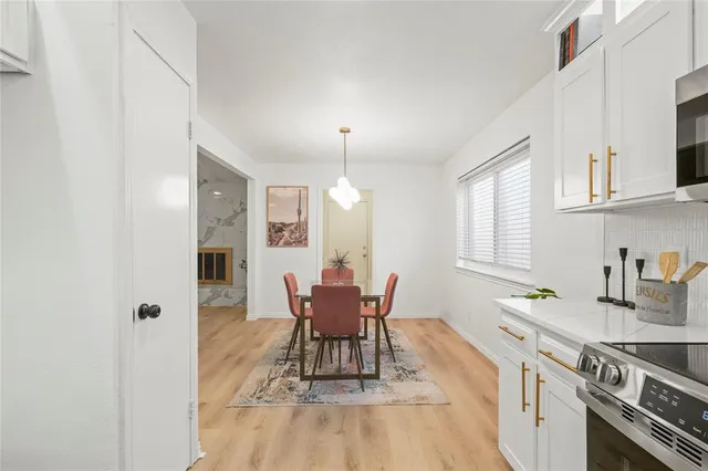 a kitchen with a dining table chairs and white cabinets
