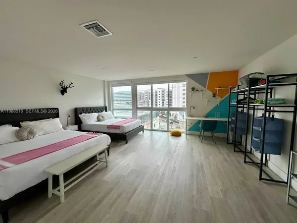 a spacious bedroom with two beds and a large window