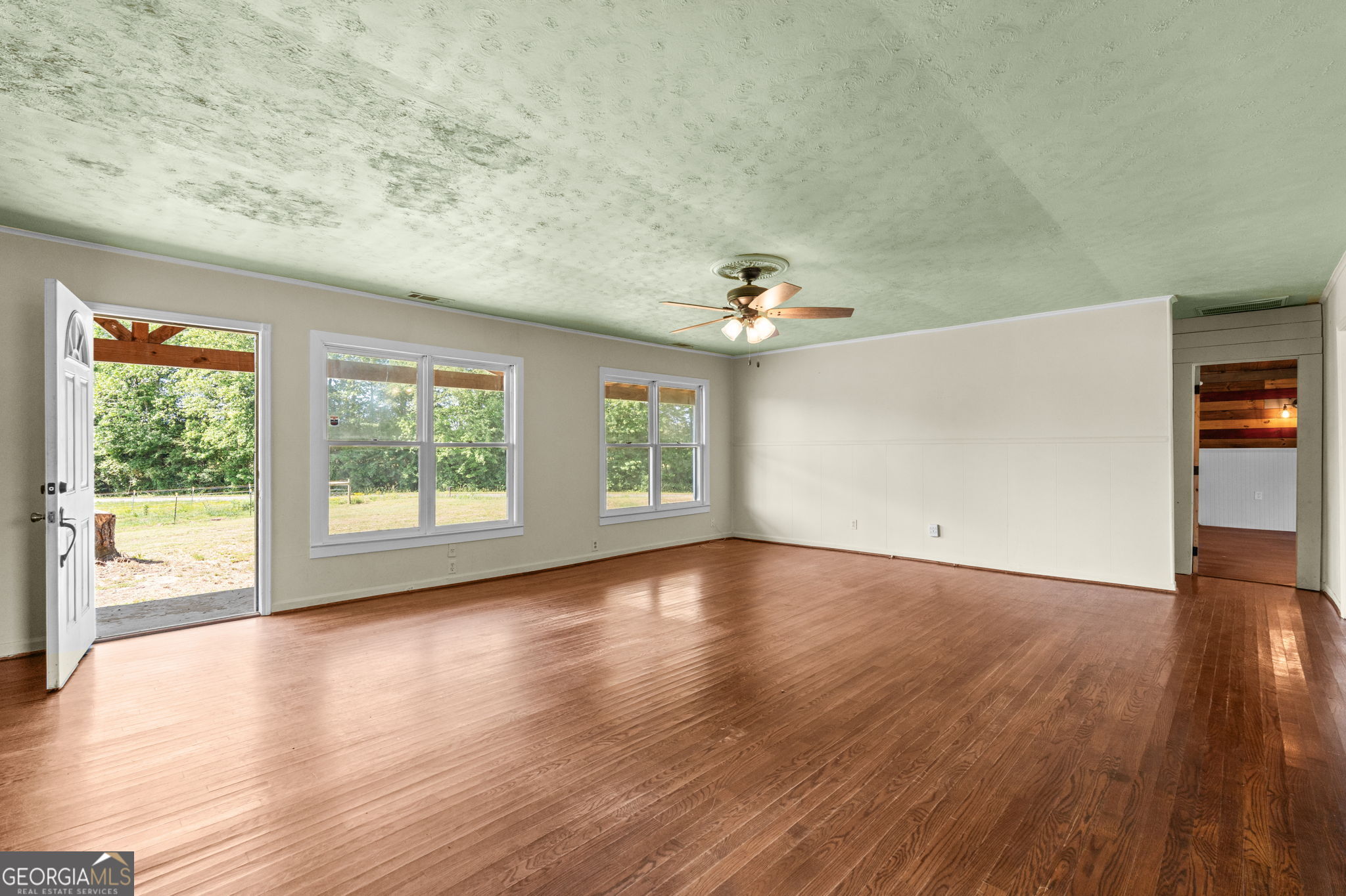 49 Frost Road Bowdon, GA 30108 - Photo 8 of 60 a view of an empty room with wooden floor and a window