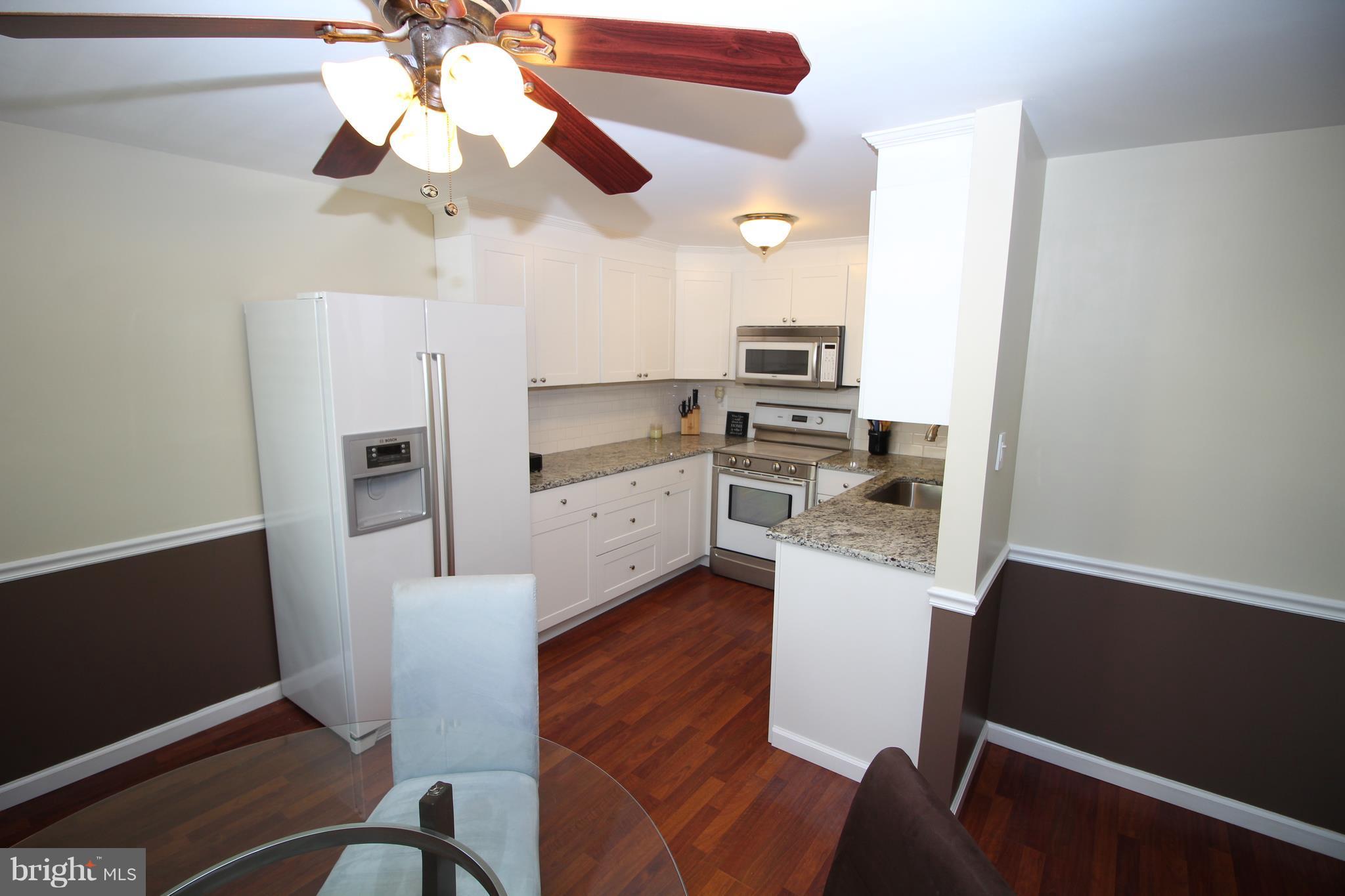 17667 Kohlhoss Road Poolesville, MD 20837 - Photo 4 of 27 a kitchen with stainless steel appliances a refrigerator and a stove top oven