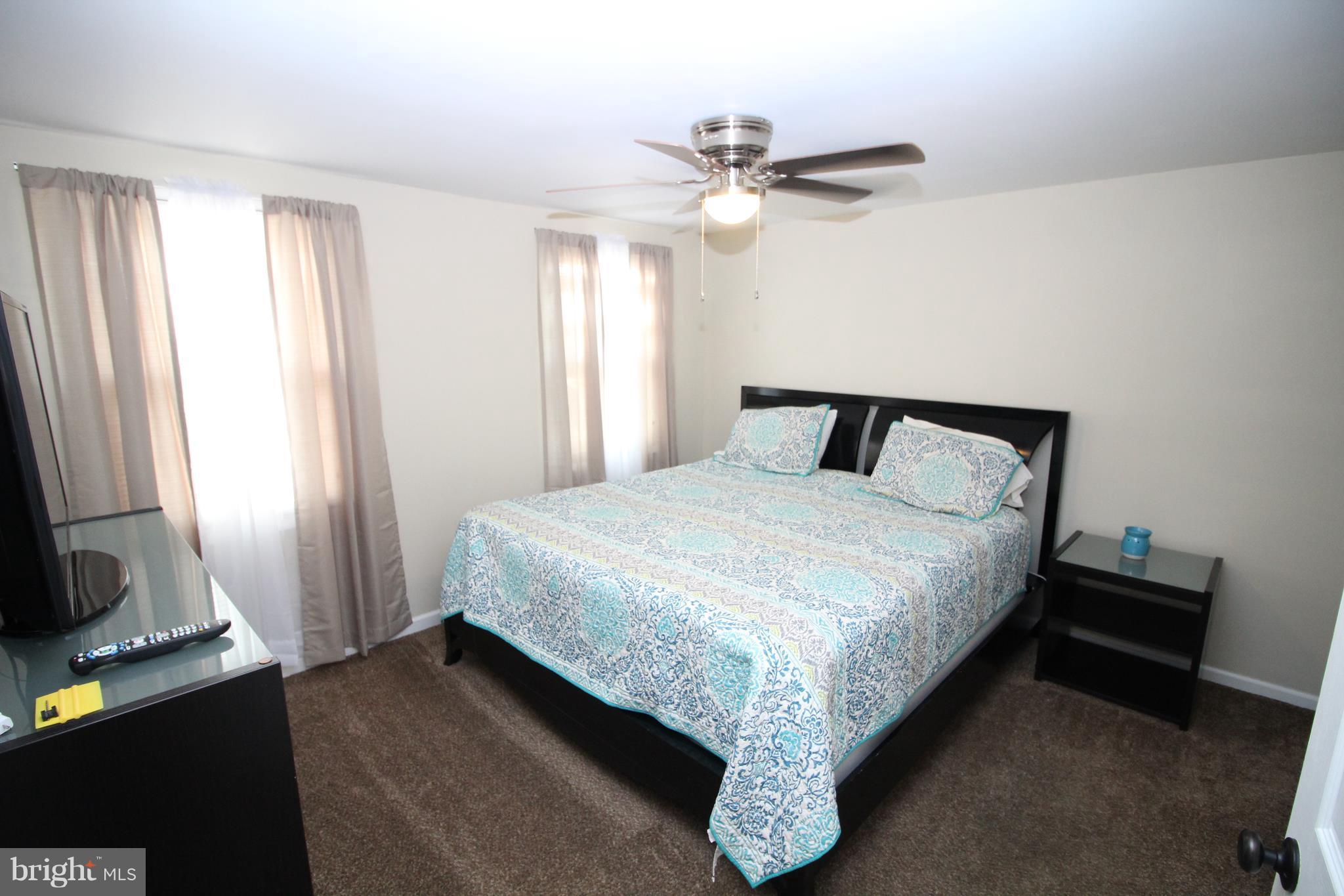 17667 Kohlhoss Road Poolesville, MD 20837 - Photo 10 of 27 a bedroom with a bed and a flat tv screen on a dresser