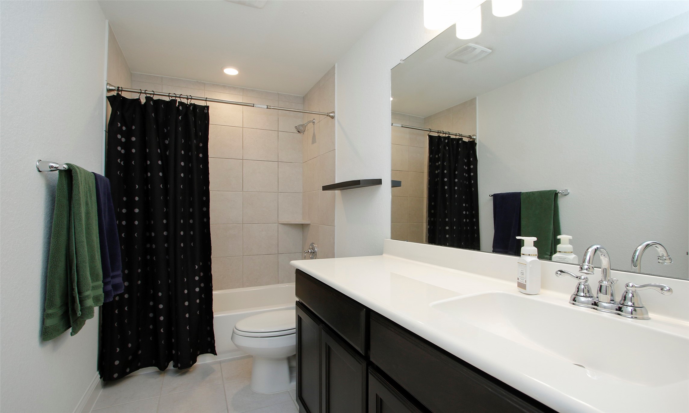 2741 Altissimo Court Spring, TX 77386 - Photo 23 of 30 The secondary bathroom featuring a dark vanity with a white countertop and a full tub with floor-to-ceiling wall tile