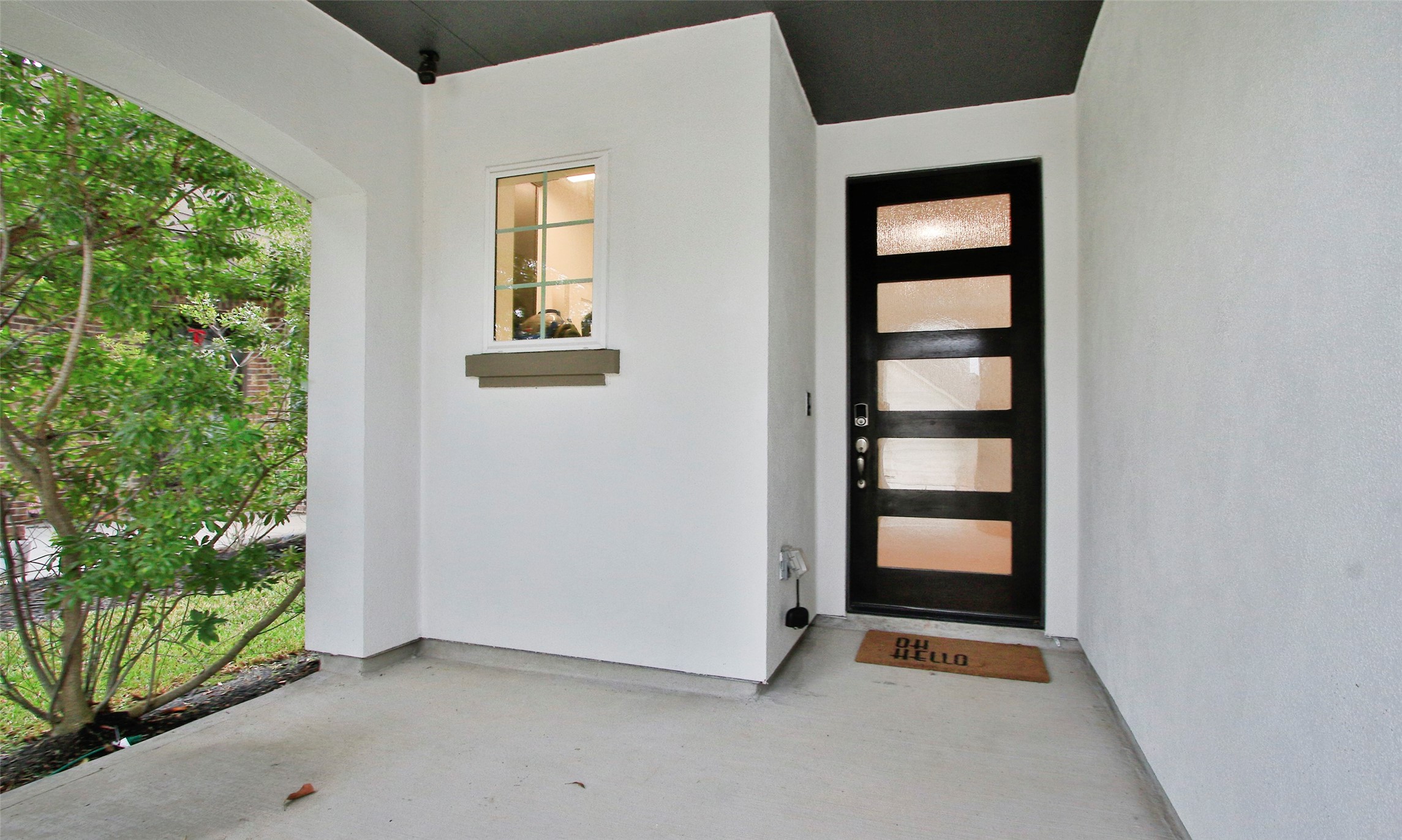 2741 Altissimo Court Spring, TX 77386 - Photo 3 of 30 The recessed entry porch offers a sheltered space with a dark-painted ceiling and a modern glass-paneled front door.