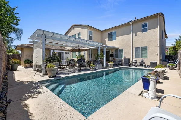 a view of a patio with couches and a table and chairs with plants