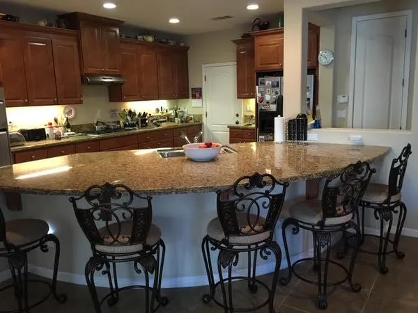 a kitchen with granite countertop a table chairs stove and cabinets