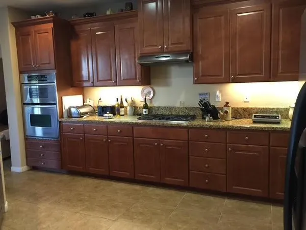 a kitchen with stainless steel appliances granite countertop wooden cabinets a sink and dishwasher
