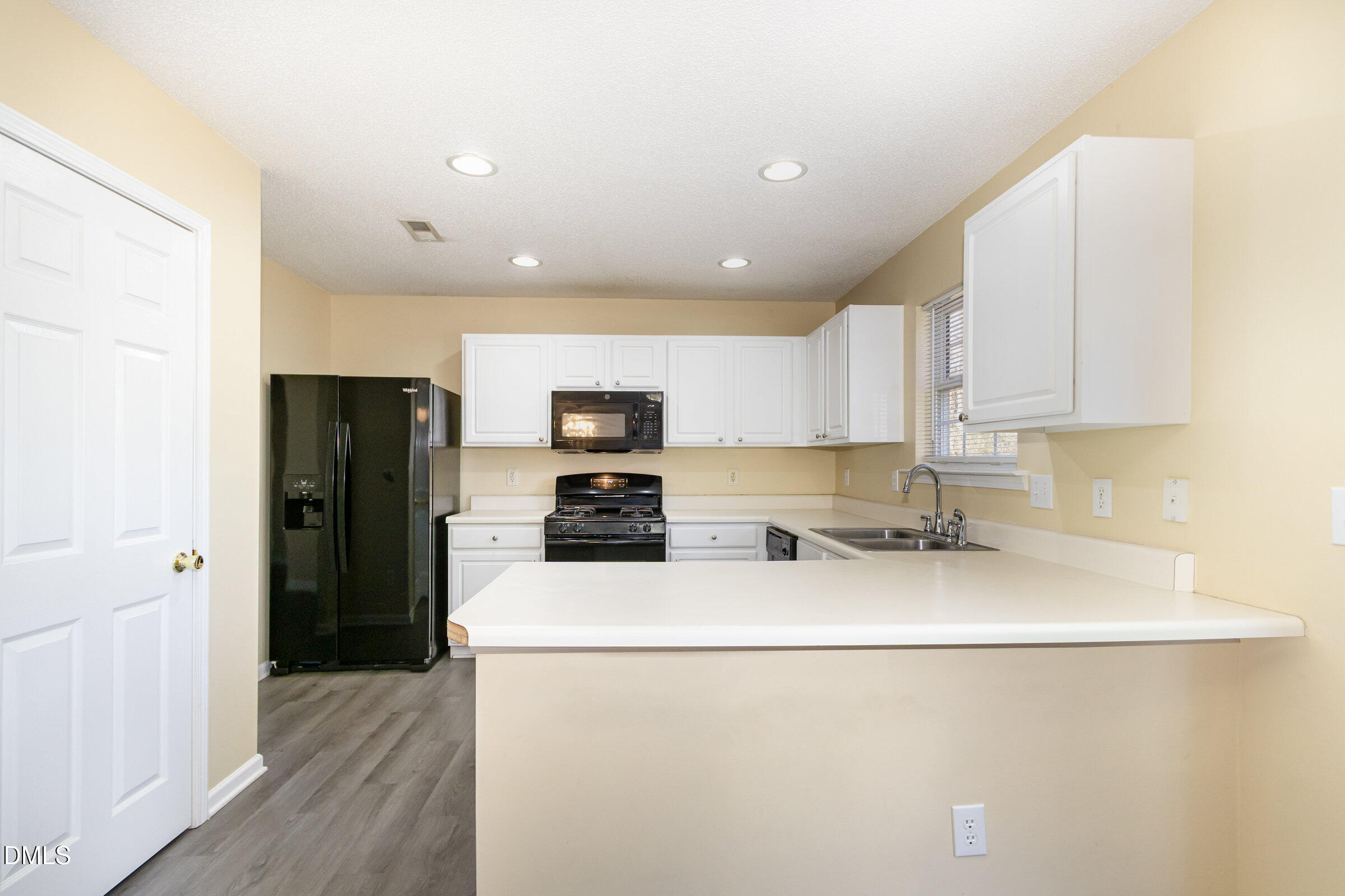 4809 Kaycee Court Raleigh, NC 27616 - Photo 21 of 41 a kitchen with stainless steel appliances a refrigerator sink and cabinets