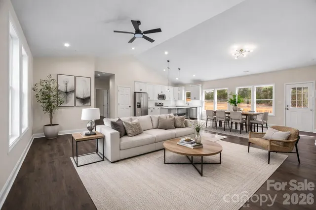 a living room with furniture and a view of kitchen