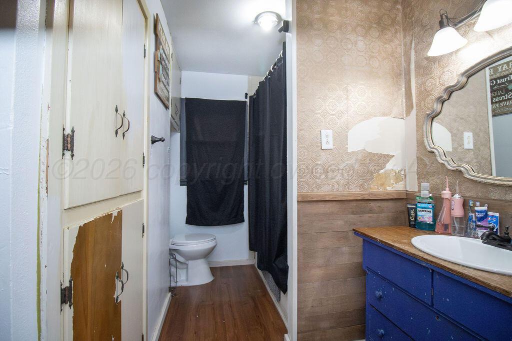 1205 Division Street Stratford, TX 79084 - Photo 11 of 14 a bathroom with a sink and a mirror