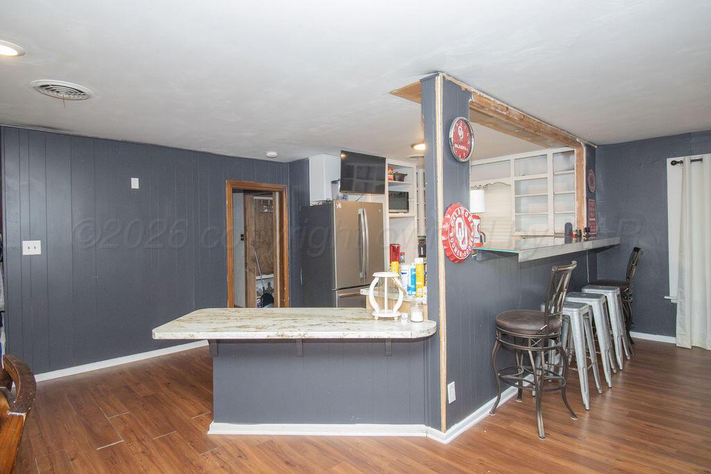 1205 Division Street Stratford, TX 79084 - Photo 6 of 14 a view of kitchen with cabinets and wooden floor