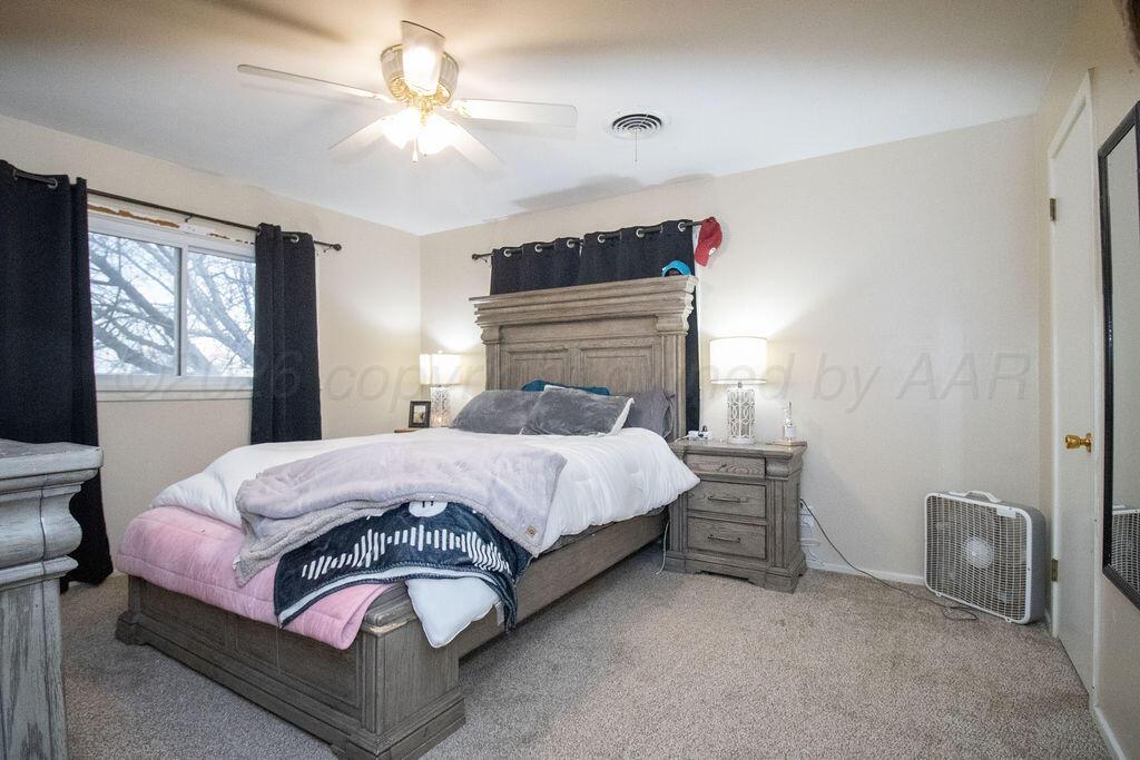 1205 Division Street Stratford, TX 79084 - Photo 7 of 14 a bedroom with a bed and a chandelier