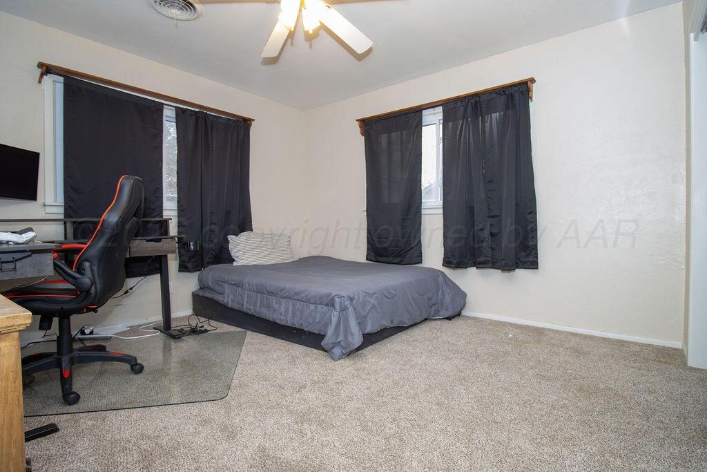 1205 Division Street Stratford, TX 79084 - Photo 8 of 14 a bedroom with a bed a desk and chair