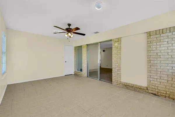 an empty room with closet and a ceiling fan