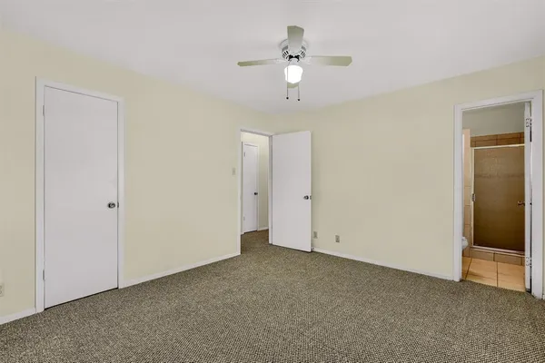 a view of an empty room with a chandelier fan