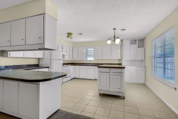 a kitchen with kitchen island granite countertop a stove a sink and a refrigerator