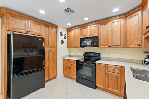 a kitchen with stainless steel appliances granite countertop a refrigerator stove and sink