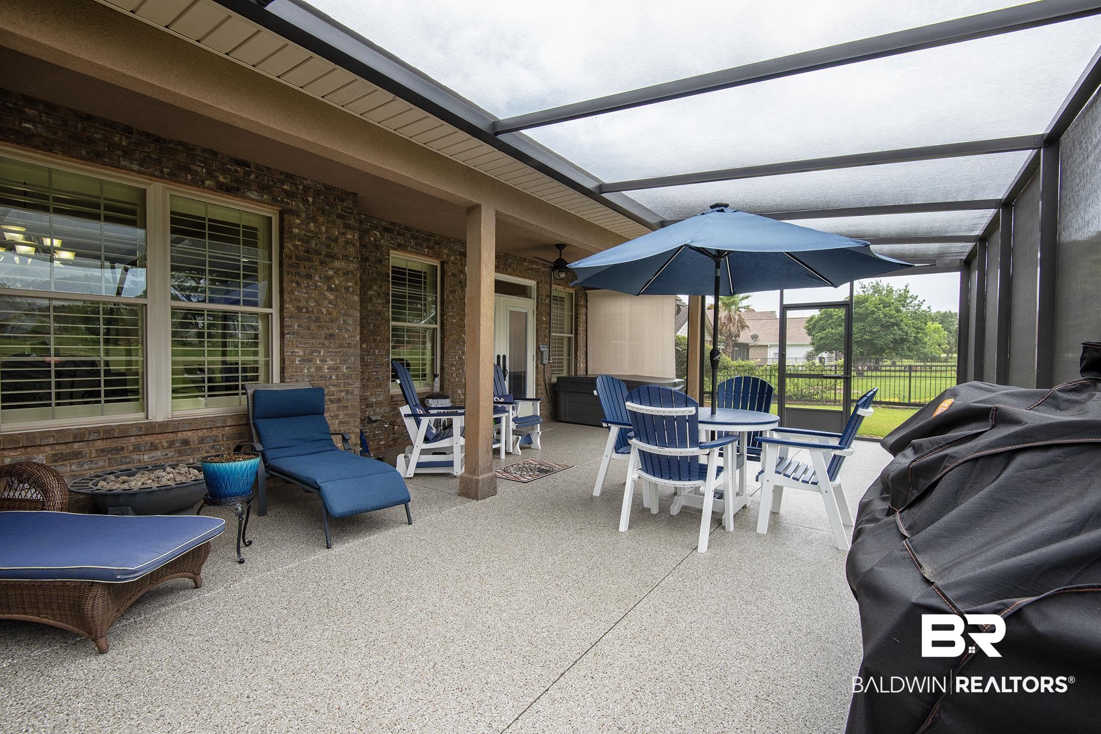 9357 Lakeview Drive Foley, AL 36535 - Photo 21 of 68 Expansive screened porch featuring a light-colored aggregate flooring, a translucent roof, and a brick exterior wall with multiple windows