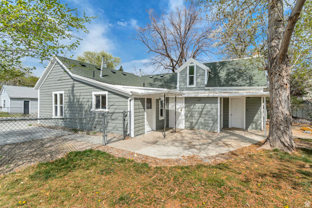 8831 South 400 East Sandy, UT 84070 - Photo 6 of 26 Back of property featuring a gate, a shingled roof, and a patio area
