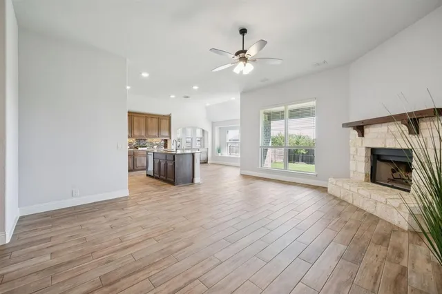 a view of a livingroom with a fireplace wooden floor and window
