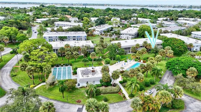 an aerial view of residential houses with outdoor space and trees all around