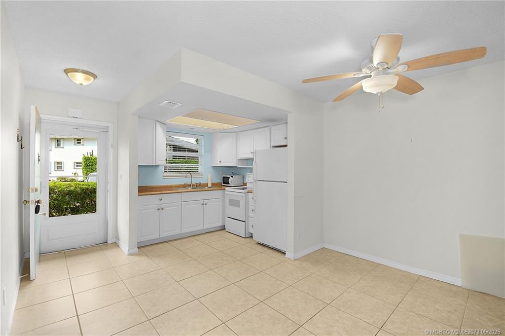 2929 Southeast Ocean Boulevard, Unit 1294 Stuart, FL 34996 - Photo 4 of 30 a kitchen with a cabinets and chandelier
