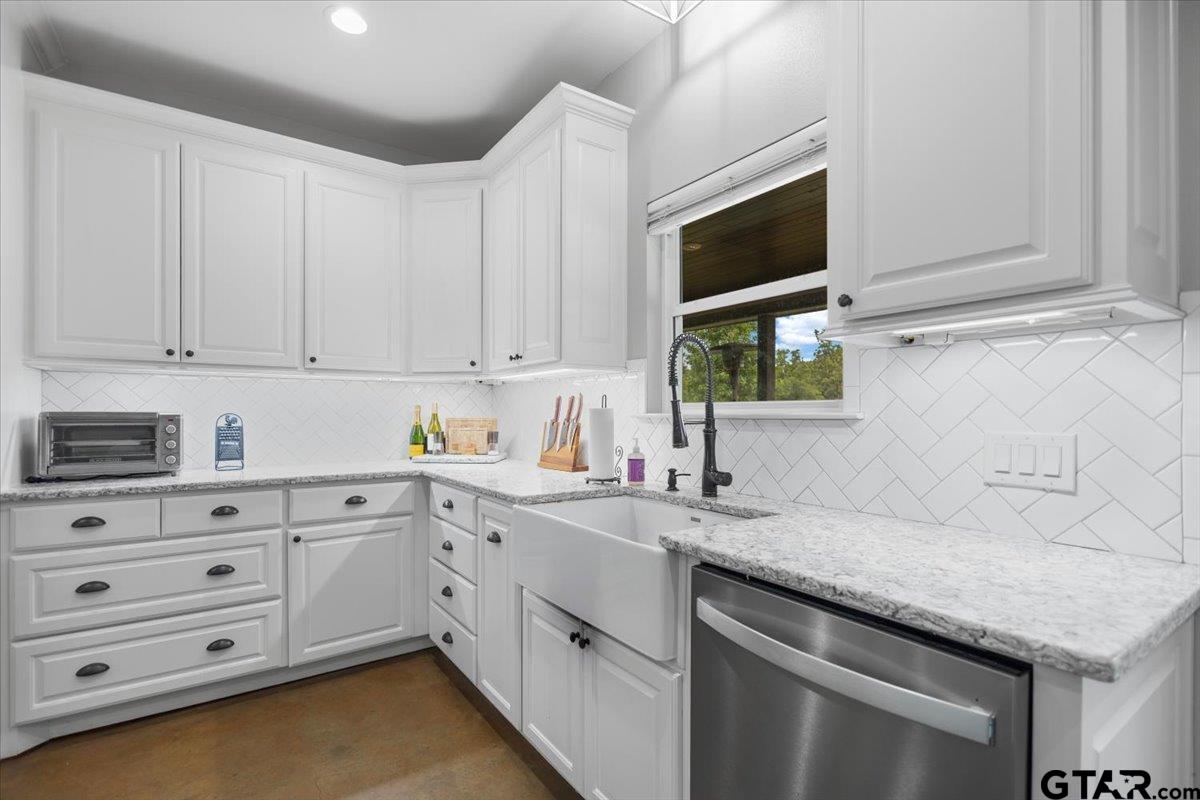 9235 Farm To Market Road 851 Rusk, TX 75785 - Photo 13 of 47 a kitchen with granite countertop a sink dishwasher and white cabinets with wooden floor