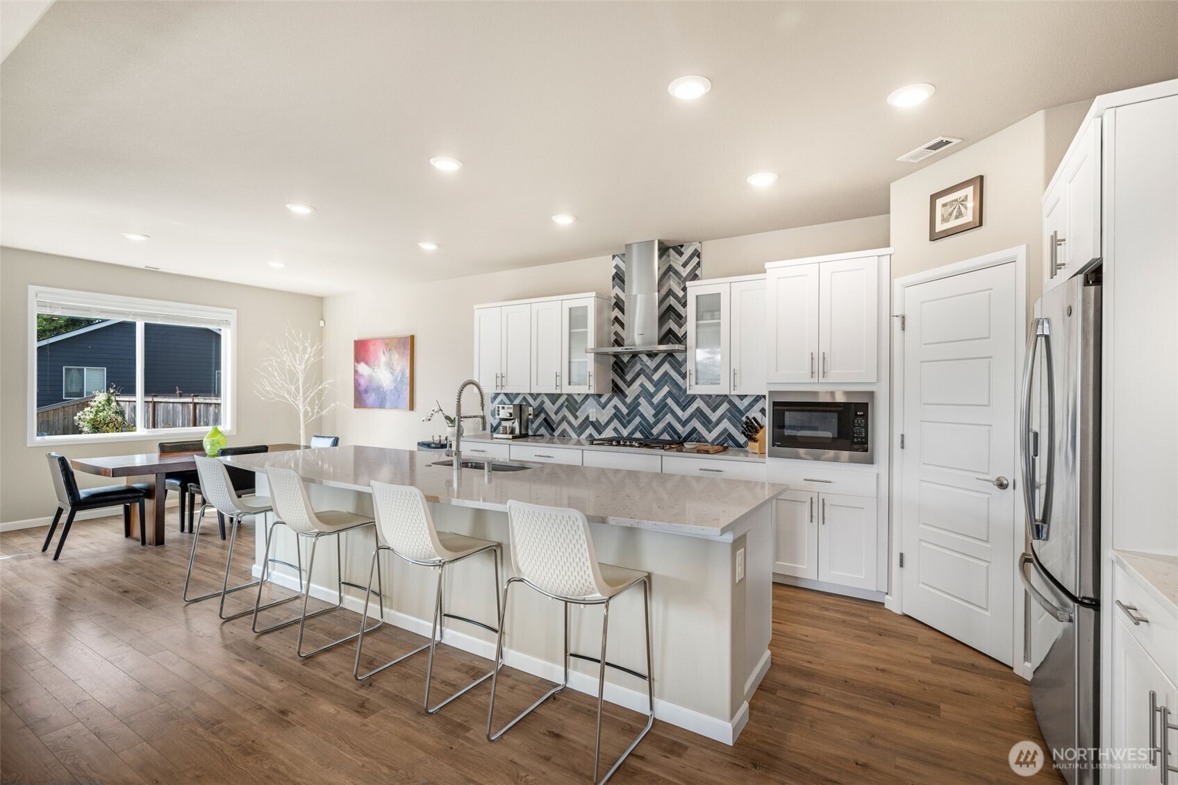 216 178th Street Southeast Bothell, WA 98012 - Photo 11 of 40 a kitchen with kitchen island granite countertop a refrigerator and wooden cabinets