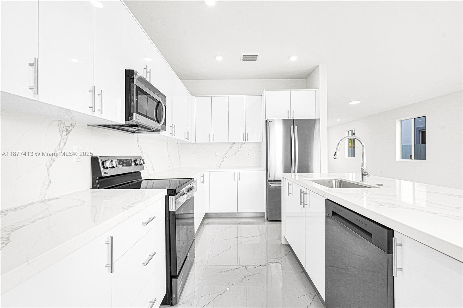 22425 Southwest 125th Avenue, Unit 19A Miami, FL 33170 - Photo 21 of 61 a kitchen with stainless steel appliances a sink stove refrigerator and cabinets
