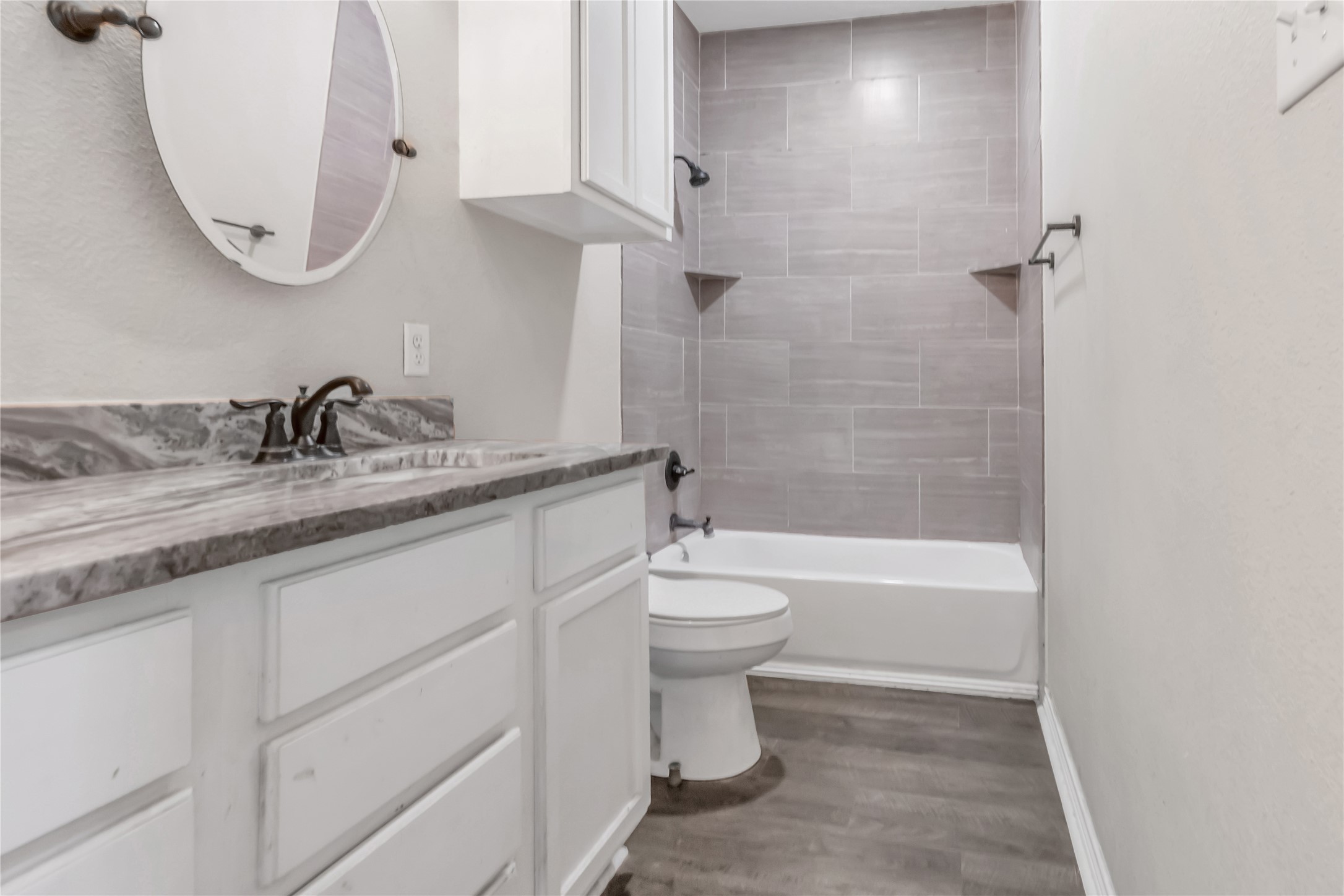 904 New York Street Bryan, TX 77803 - Photo 6 of 11 a bathroom with a granite countertop sink a toilet and bathtub