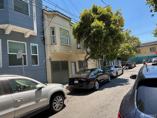 a couple of cars parked in front of a house